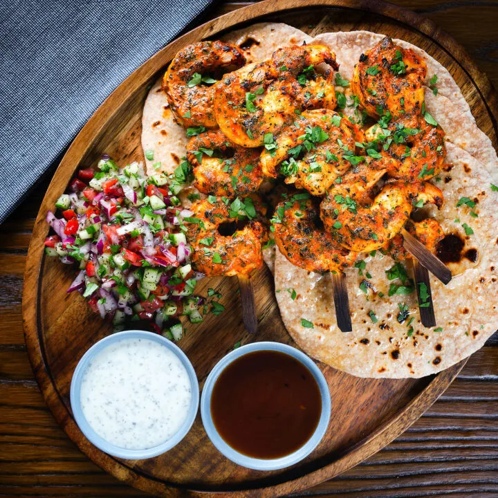 Indian tandoori king prawns with chapatis, kachumber salad, mint raita and tamarind chutney.