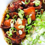 Overhead close-up Vietnamese coconut caramel chicken served with jasmine rice and spring onions.