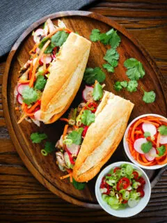 Overhead Vietnamese-influenced chicken banh mi sandwiches on a French baguette.