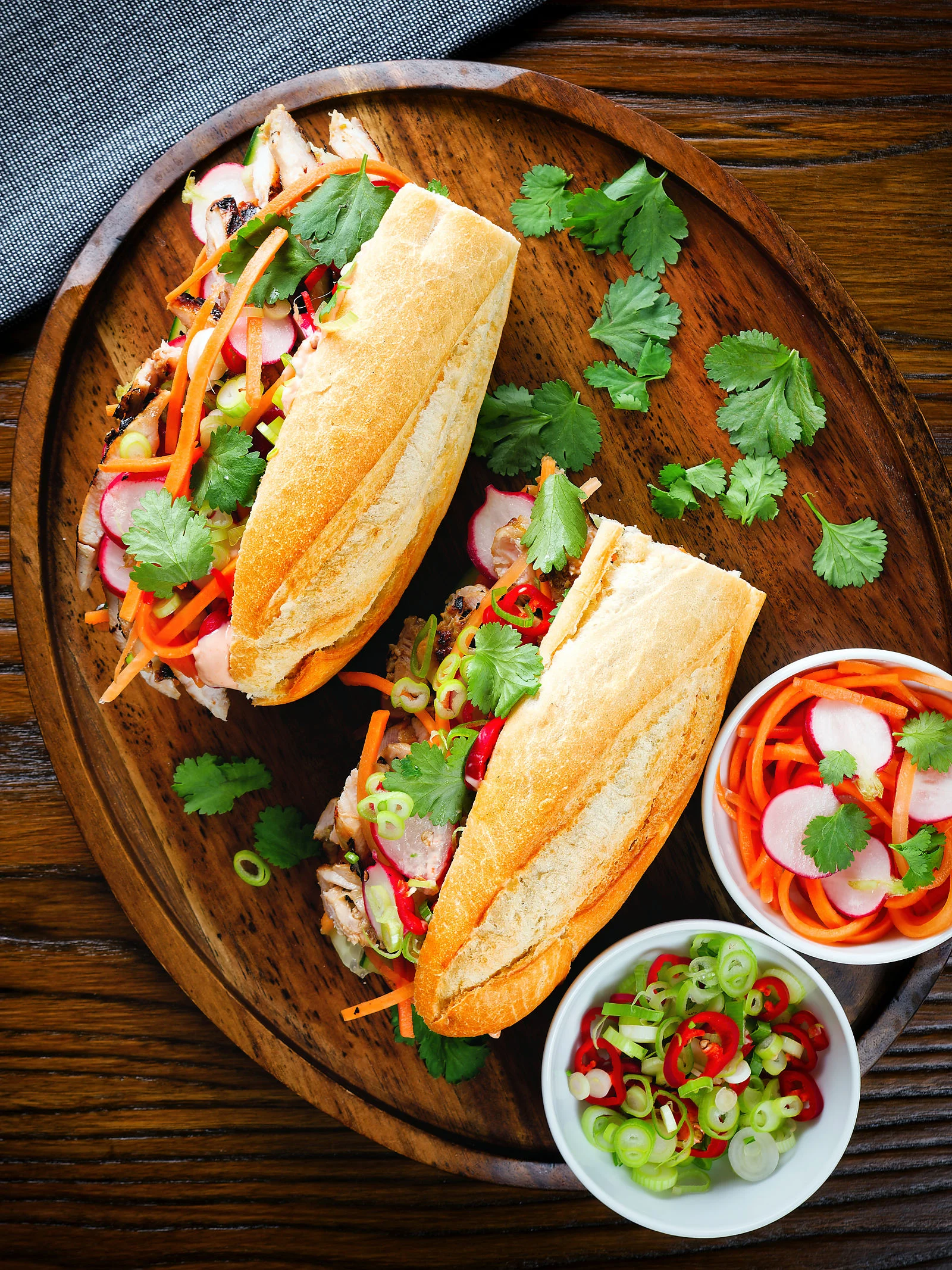Overhead Vietnamese-influenced chicken banh mi sandwiches on a French baguette.