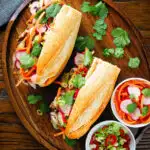 Overhead Vietnamese-influenced chicken banh mi sandwiches on a French baguette.