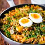 Anglo-Indian smoked mackerel kedgeree (rice) served with boiled egg in a cooking pan.