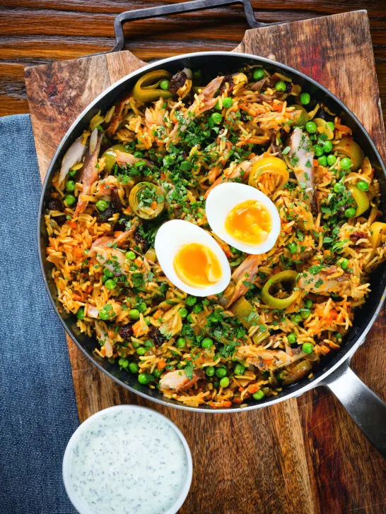 Overhead smoked mackerel kedgeree (rice) served with boiled egg in a cooking pan.