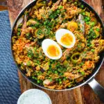 Overhead smoked mackerel kedgeree (rice) served with boiled egg in a cooking pan.