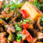 Close-up Cuban inspired minced beef picadillo with potatoes, raisins, capers and brown rice.