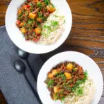 Overhead Cuban minced beef picadillo with potatoes, raisin, capers and brown rice.