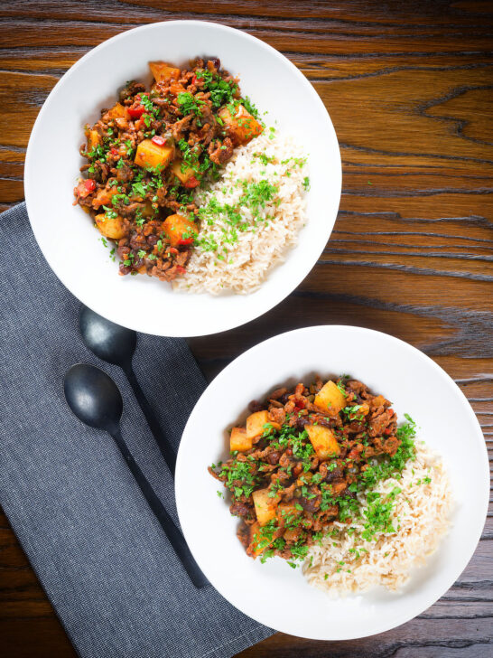 Overhead Cuban minced beef picadillo with potatoes, raisin, capers and brown rice.