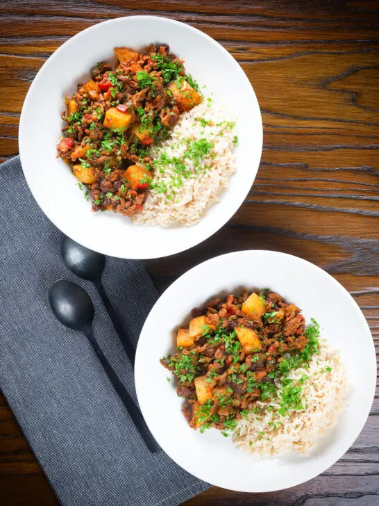 Overhead Cuban minced beef picadillo with potatoes, raisin, capers and brown rice.