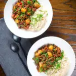 Overhead Cuban minced beef picadillo with potatoes, raisin, capers and brown rice.