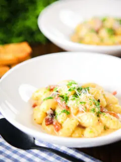 Creamy gnocchi carbonara with pecorino cheese and fresh parsley served with garlic bread.
