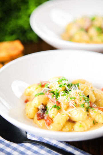 Creamy gnocchi carbonara with pecorino cheese and fresh parsley served with garlic bread.