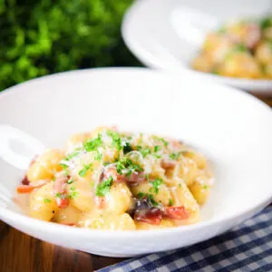 Rich and creamy gnocchi carbonara with pecorino cheese and fresh parsley served with garlic bread.