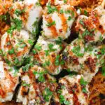 Close-up overhead Greek chicken souvlaki kebabs served with pourgouri and a yoghurt sauce.