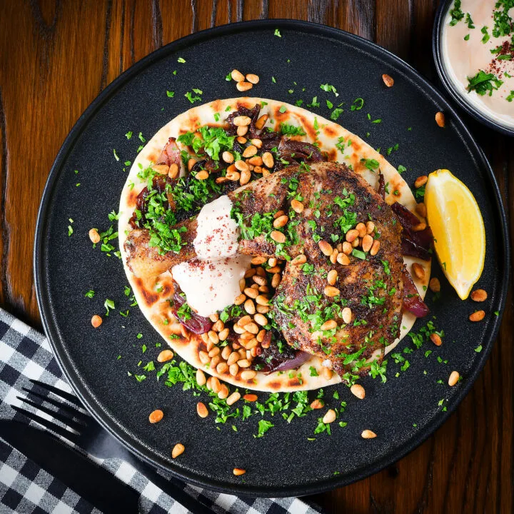 Palestinian sumac chicken musakhan on flatbread with pine nuts, caramelised onions and yoghurt.