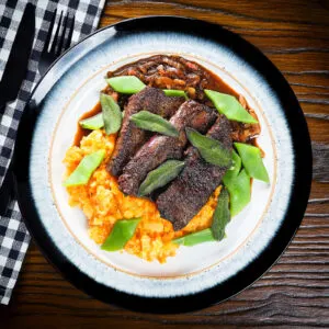 Pan fried calves liver with onion and bacon gravy, swede and carrot mash, beans and sage.