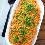 Overhead pourgouri Cypriot/Greek bulgur and vermicelli noodle pilaf garnished with fresh parsley.