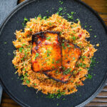 Overhead Cypriot pourgouri pilafi served with honey glazed halloumi and fresh parsley.