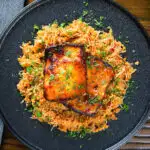 Overhead Cypriot pourgouri pilafi served with honey glazed halloumi and fresh parsley.