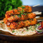 Indian salmon tikka kebabs served with roti, kachumber salad and raita.