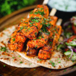 Indian salmon tikka skewers served with roti, kachumber salad and raita.