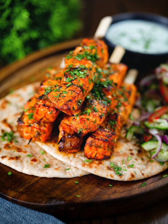 Indian salmon tikka skewers served with roti, kachumber salad and raita.