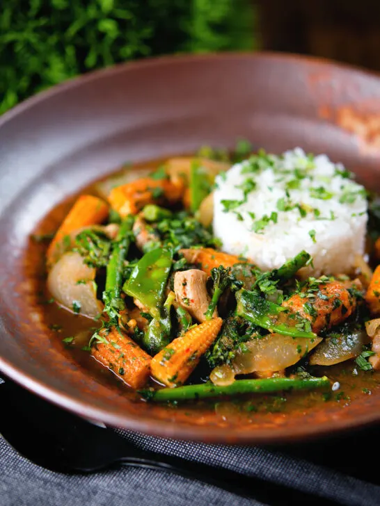 Thai chicken jungle curry (kaeng pa) served with jasmine rice and fresh herbs.