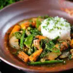 Thai chicken jungle curry (kaeng pa) served with jasmine rice and fresh herbs.