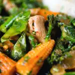 Close-up Thai chicken jungle curry (kaeng pa) served with jasmine rice and fresh herbs.