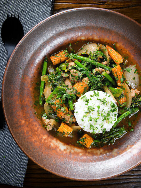 Overhead Thai chicken jungle curry (kaeng pa) served with jasmine rice and fresh herbs.