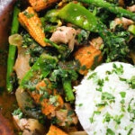 Close-up overhead Thai chicken jungle curry (kaeng pa) served with jasmine rice and fresh herbs.