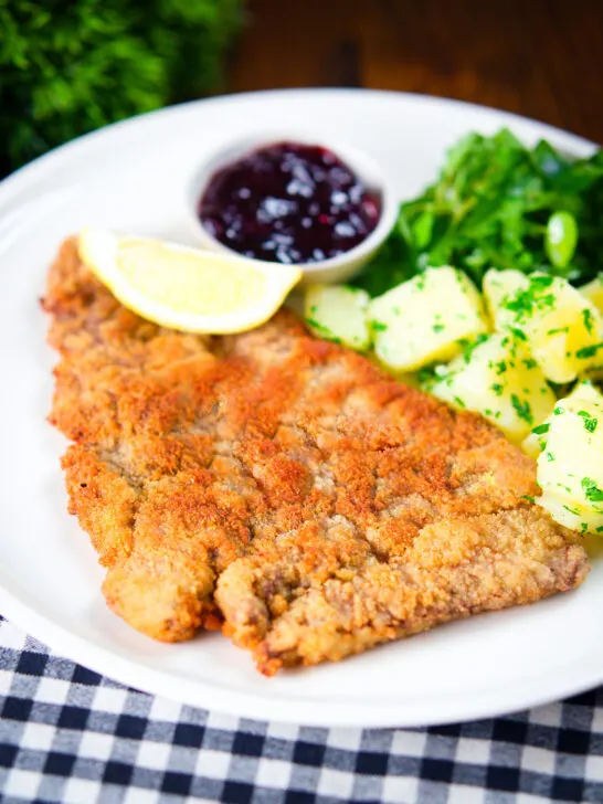 Breaded veal Wiener schnitzel served with parsley buttered potatoes and redcurrant jelly.