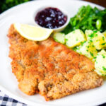 Breaded veal Wiener schnitzel served with parsley buttered potatoes and redcurrant jelly.