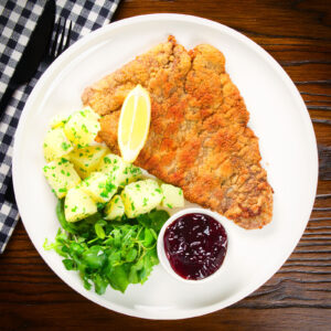 Wiener Schnitzel, breaded veal cutlet with parsley potatoes and red currant jelly.