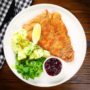 Wiener Schnitzel, breaded veal cutlet with parsley potatoes and red currant jelly.