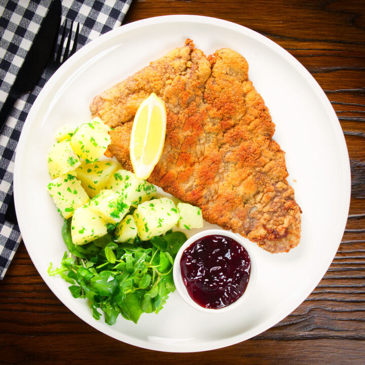 Wiener Schnitzel, breaded veal cutlet with parsley potatoes and red currant jelly.