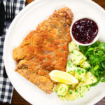Overhead breaded veal Wiener schnitzel served with parsley buttered potatoes and redcurrant jelly.