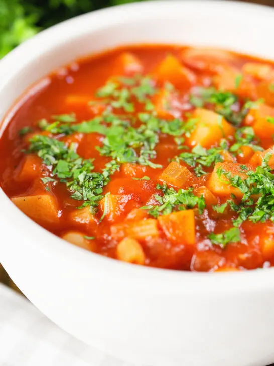 Close-up vegetarian winter root vegetable soup served with fresh parsley.