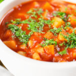 Close-up vegetarian winter root vegetable soup served with fresh parsley.
