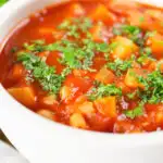 Close-up vegetarian winter root vegetable soup served with fresh parsley.