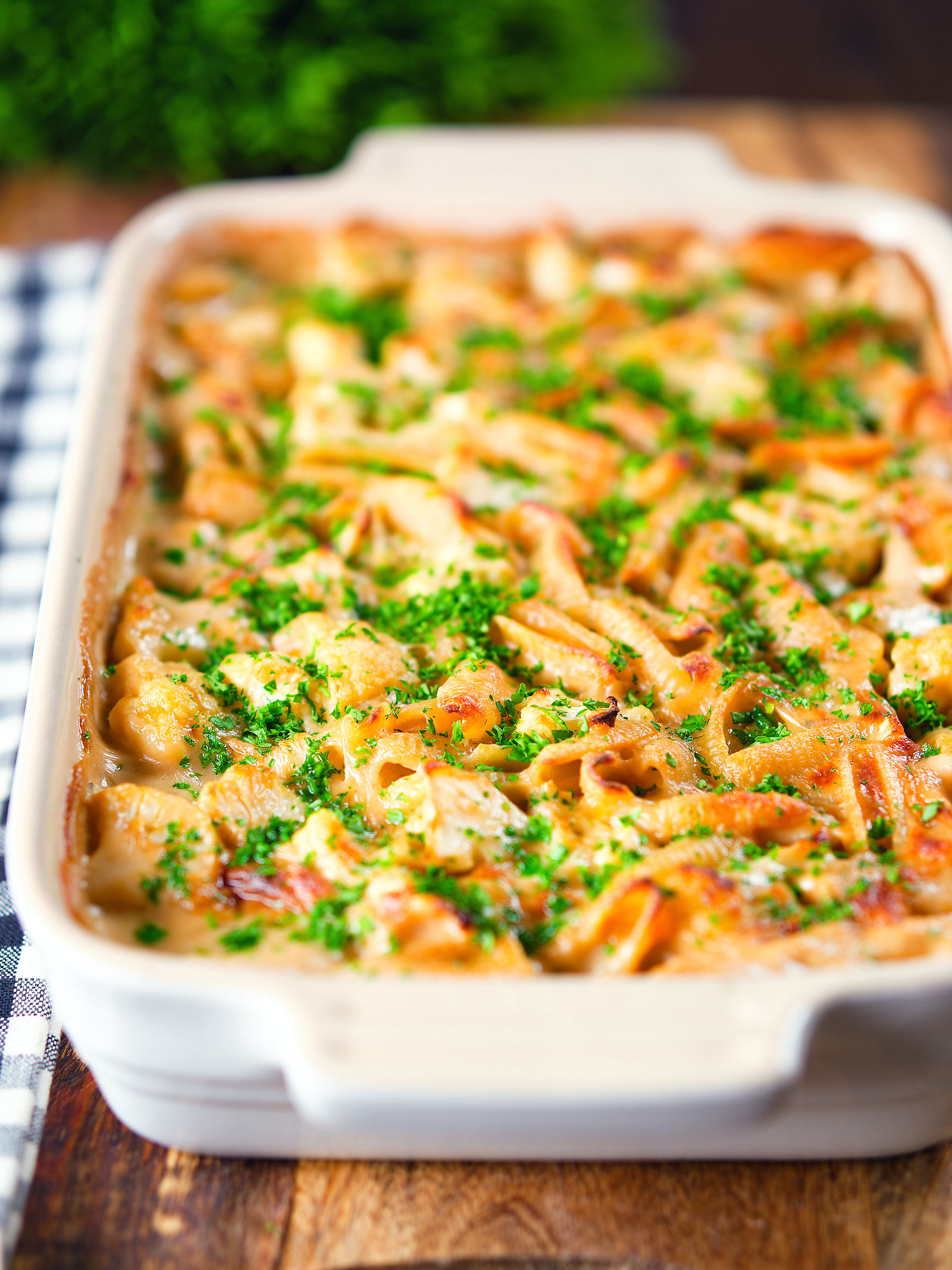 Cauliflower cheese pasta bake served in a baking dish with parsley.