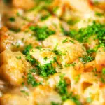 Close-up cauliflower cheese pasta bake served in a baking dish with parsley.