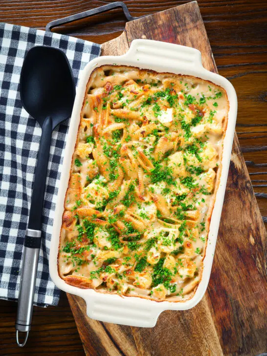 Overhead cauliflower cheese pasta bake served in a baking dish with parsley.