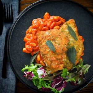 Chicken Milanese (breaded fried chicken culets) served with fagioli all'uccalletto.