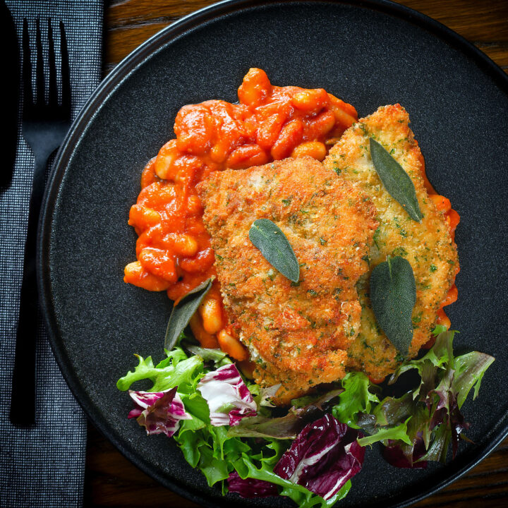 Chicken Milanese (breaded fried chicken culets) served with fagioli all'uccalletto.