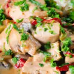 Close-up creamy chicken a la king served with brown rice and parsley.