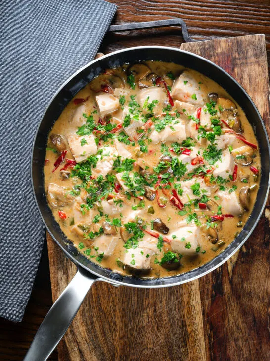 Overhead creamy chicken a la king served with fresh parsley in its cooking pan.