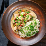 Creamy chicken a la king served with brown rice and fresh parsley.