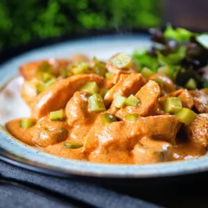 Creamy chicken and mushroom stroganoff served with fried potatoes and salad.