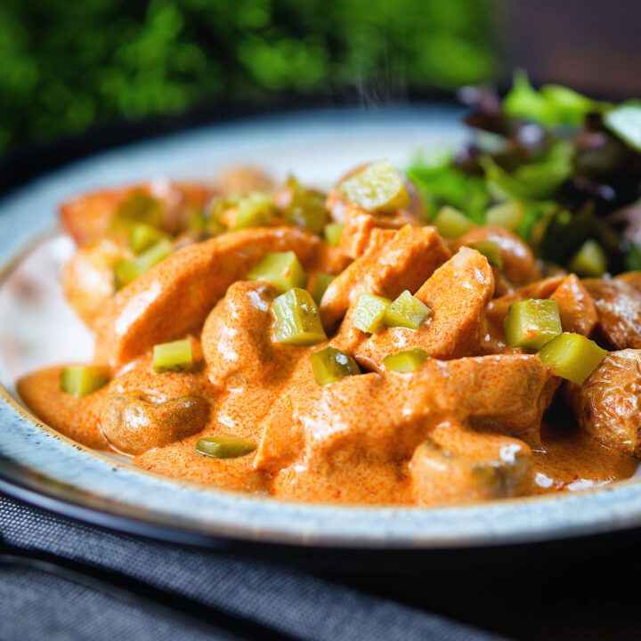 Creamy chicken and mushroom stroganoff served with fried potatoes and salad.