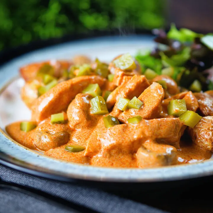 Creamy chicken and mushroom stroganoff served with fried potatoes and salad.
